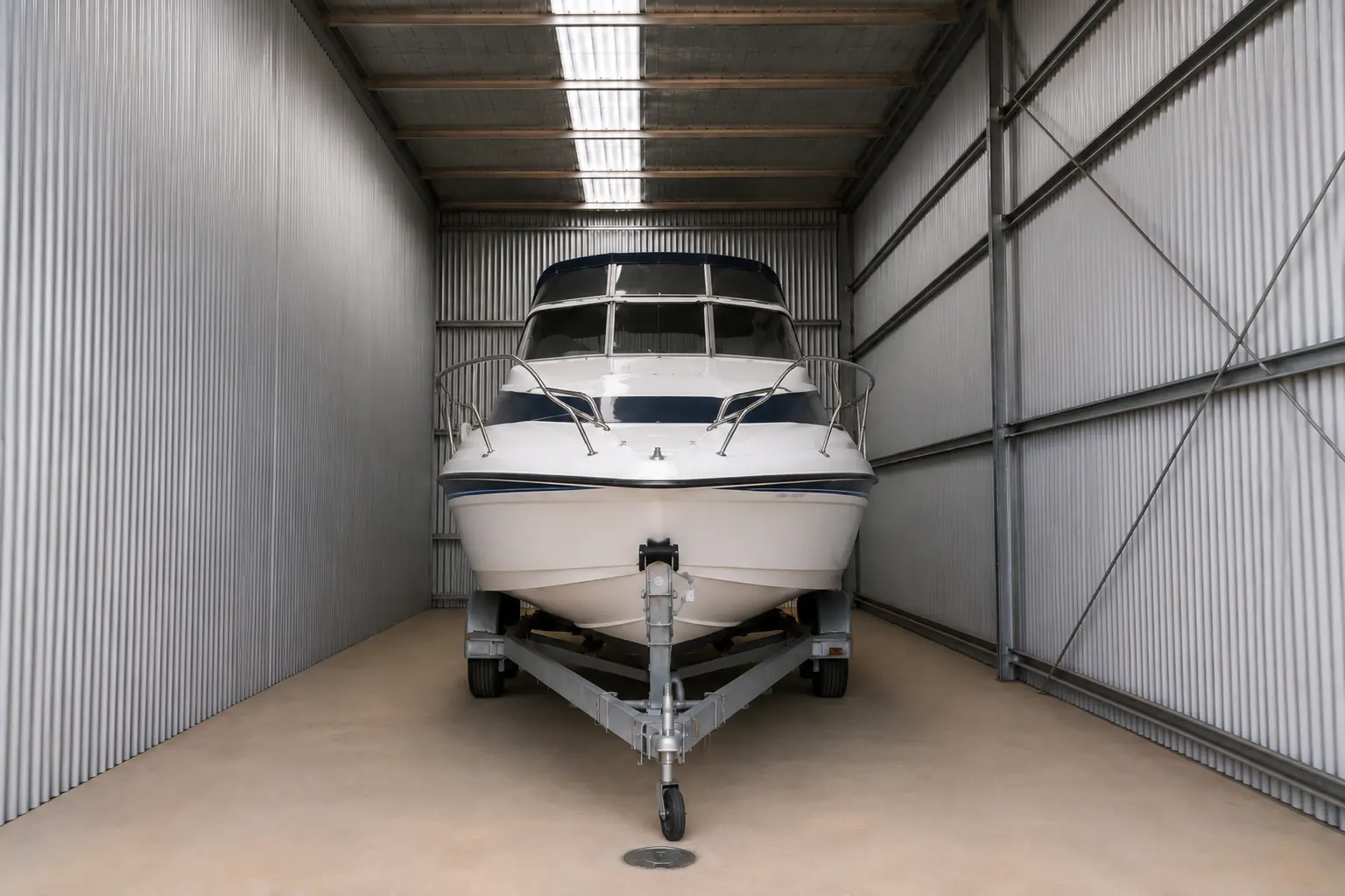 White motorboat stored indoors in a secure boat storage facility near Lake Eildon