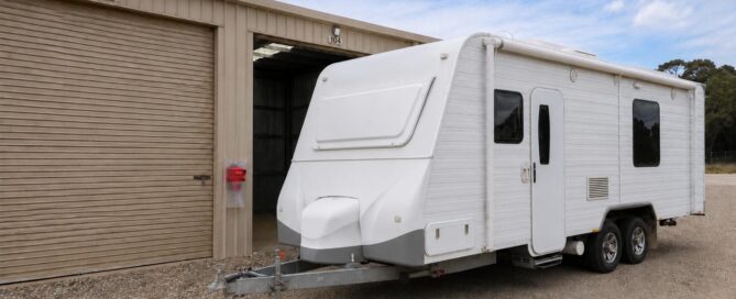 A secure caravan storage unit with a white trailer parked outside