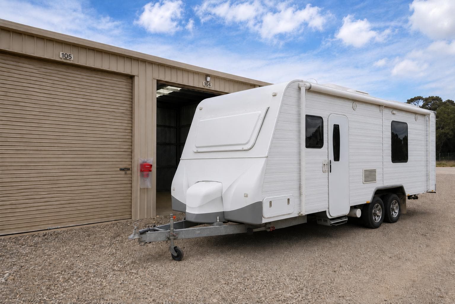 A secure caravan storage unit with a white trailer parked outside